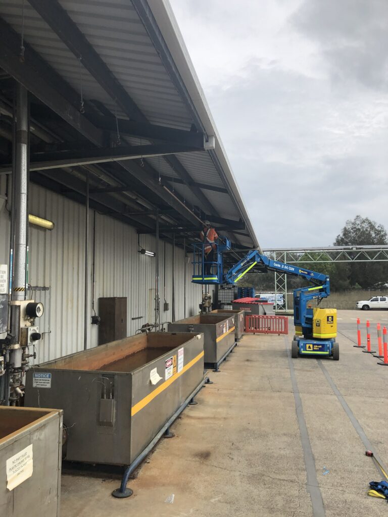 Worker installing new water pipes at a factory