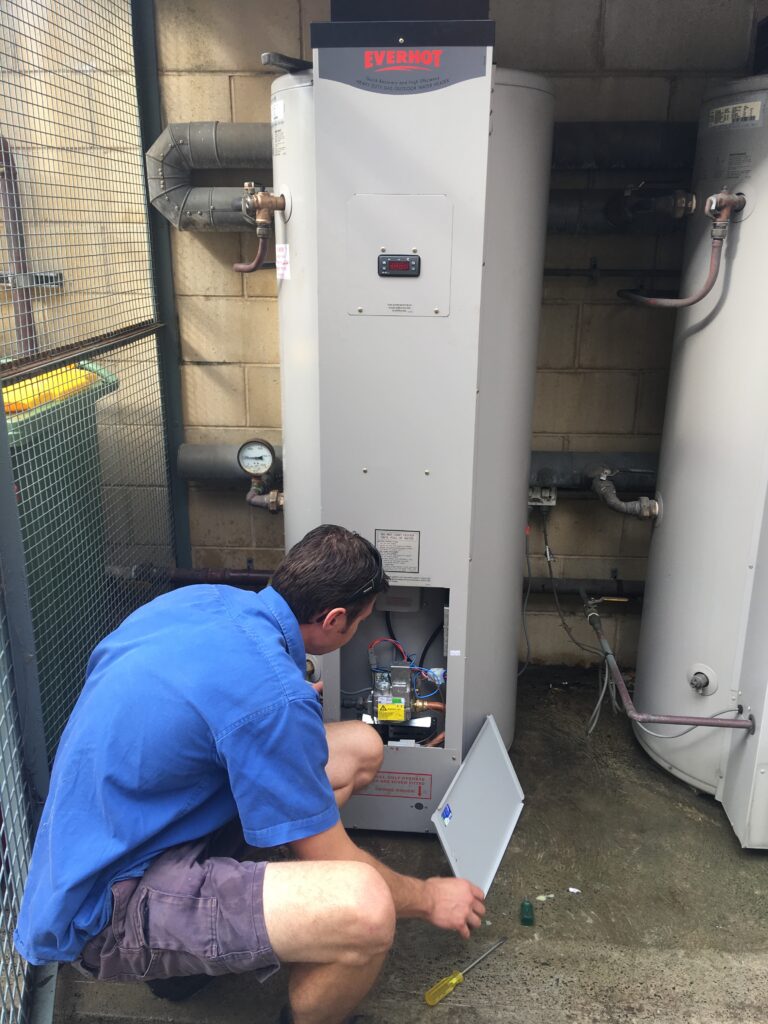 man repairing a gas hot water system