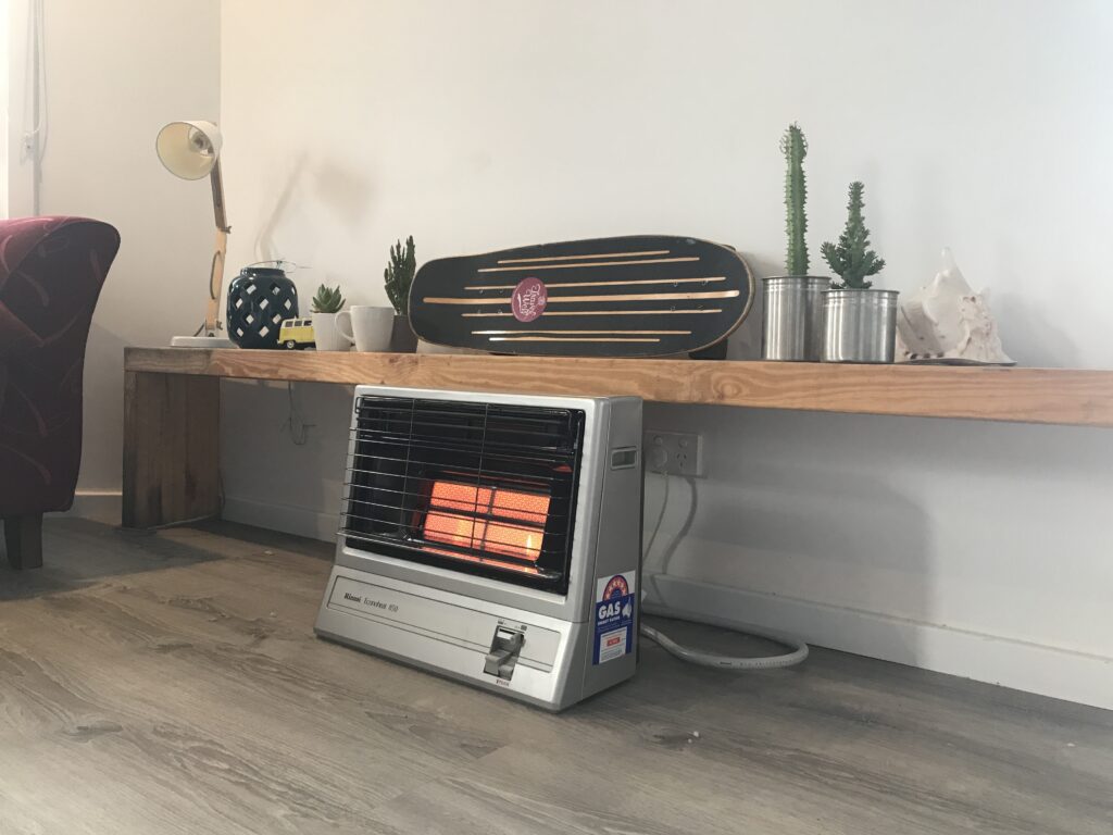 Gas Heater in a cosey room with a skate board on a mantle piece